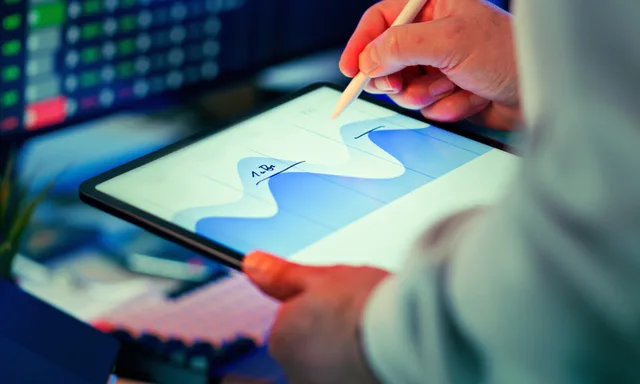 Professional analyzing data chart on a tablet with stylus in an office setting. Metode og kilder: Sådan vurderer du datakvalitet